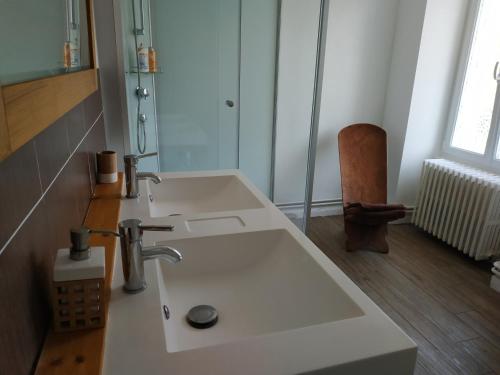 La salle de bains est pourvue d'un lavabo blanc. dans l'établissement La Maison Du Lavoir, à Payroux