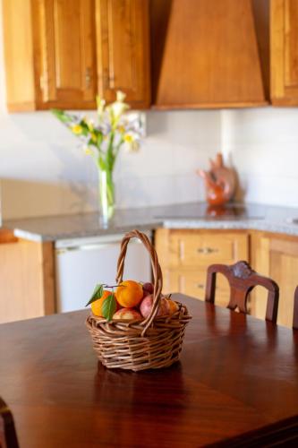 a basket of fruit sitting on a table in a kitchen at Casas da Lagariça in Sortelha