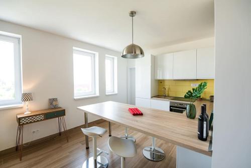 eine Küche mit einem großen Holztisch und Stühlen in der Unterkunft Chez Emile Private 5 star 3 room flat and in-door Pkg in Nitra