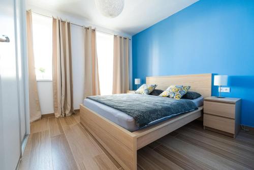 Dormitorio azul con cama y pared azul en Chez Emile Private 5 star 3 room flat and in-door Pkg, en Nitra