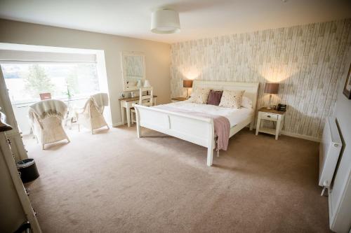 a bedroom with a white bed and a window at Château Rhianfa in Menai Bridge