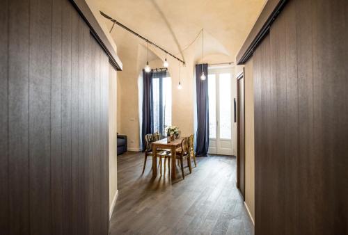 a hallway with a table and chairs in a room at La Canonica - charming self-catering apartments in Nizza Monferrato in Nizza Monferrato