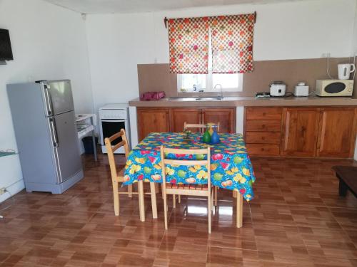 een keuken met een tafel met stoelen en een koelkast bij Hebergement Vue Sur Mer in Rodrigues Island