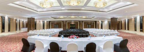 a banquet hall with white tables and chairs at Golden Tulip Chandigarh, Panchkula in Chandīgarh