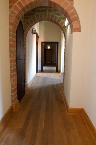 an empty hallway with a brick wall and a door at Zamek Golubski in Golub-Dobrzyń