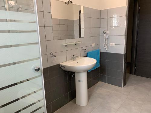 un bagno con lavandino e specchio di Binja Fortuna a Àrbatax