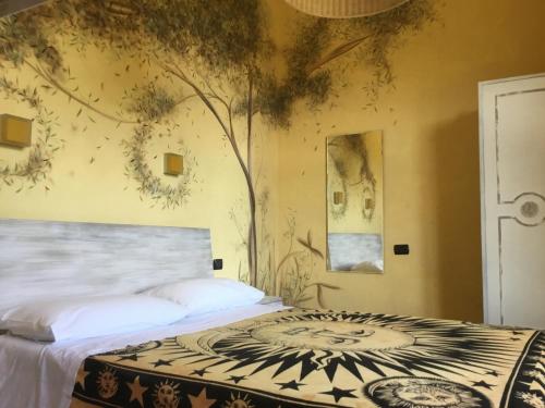 a bedroom with a bed with a tree mural on the wall at Cinqueterre Alla Chetichella in Lerici