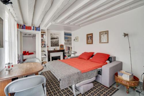 une chambre avec un lit, une table et des chaises dans l'établissement Saint Germain dès Pres Paris VI° - Unit 003, à Paris