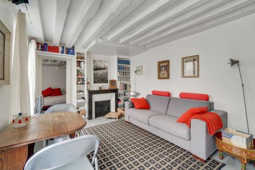 un salon avec un canapé et une table dans l'établissement Saint Germain dès Pres Paris VI° - Unit 003, à Paris