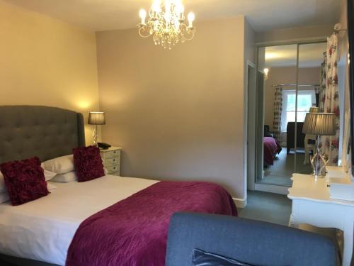 a bedroom with a bed and a chandelier at Dale Head Hall Lakeside Hotel in Keswick