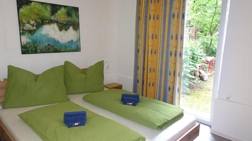 een slaapkamer met een bed met groene kussens en een raam bij Luna Apartments in Wenen