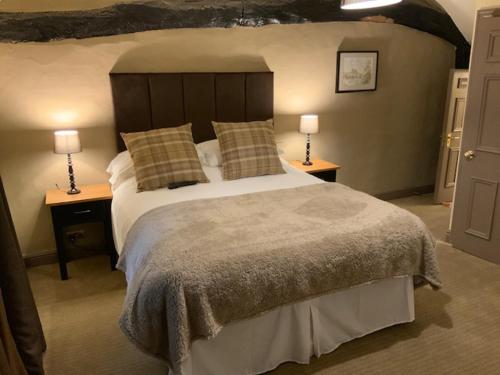 a bedroom with a large bed with two lamps on tables at The Swan and Talbot in Wetherby