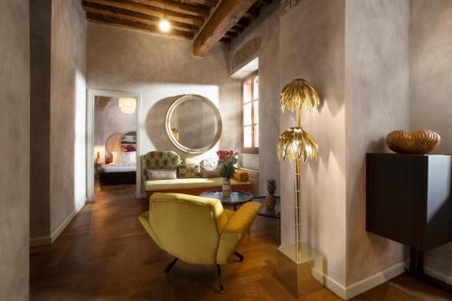 a living room with a yellow chair and a mirror at Palm Suites - Small Luxury Hotels of the World in Rome