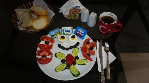 a plate of food with vegetables and a cup of coffee at PAPİLLONADA HOTEL in Aydın