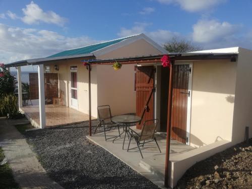 a house with a patio with chairs and a table at Chez Mimi in Rodrigues Island