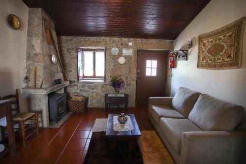 a living room with a couch and a fireplace at Casas da Lagariça in Sortelha