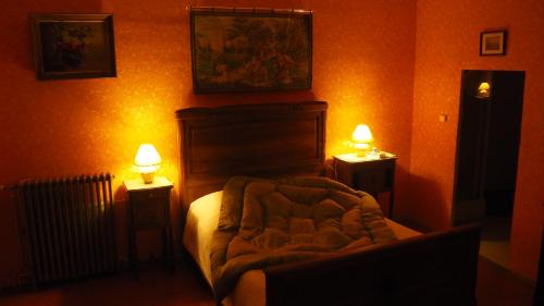 a bedroom with a bed and two lights on the wall at Maison du Parc in Saint-Chinian