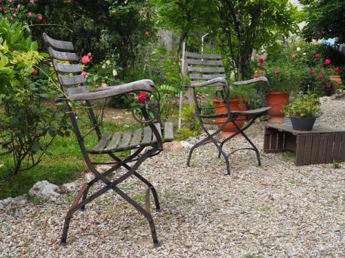 two rocking chairs and a table in a garden at Maison du Parc in Saint-Chinian