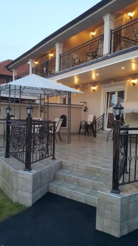 a house with a patio with a table and an umbrella at Apartments Exclusive in Belgrade