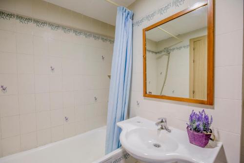 a bathroom with a sink and a mirror and a tub at Rentalmar Azahar in Salou