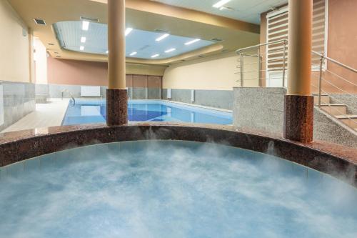 a swimming pool with a pool table and a tub at Hotel Bistra, Resort Mavrovo in Mavrovo