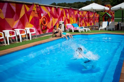 Dos personas están jugando en una piscina en Hotel Restaurante Cadosa, en Soria