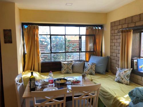 Zimmer mit einem Esstisch und einem Fenster in der Unterkunft Out of the Wilderness in Midreshet Ben Gurion