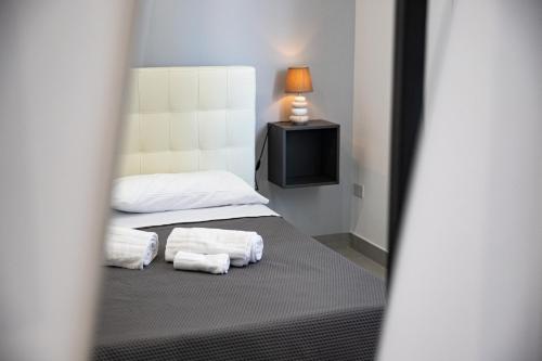 a bedroom with two towels on a bed with a television at b&b Zio Luciano in Avola