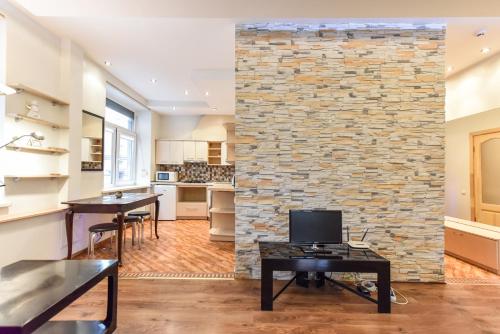 a kitchen and living room with a stone wall at Apartment Liepu str. in Klaipėda