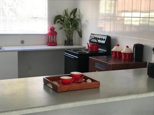 a kitchen with red bowls on a tray on a counter at Tortilla no 3 in Bloemfontein