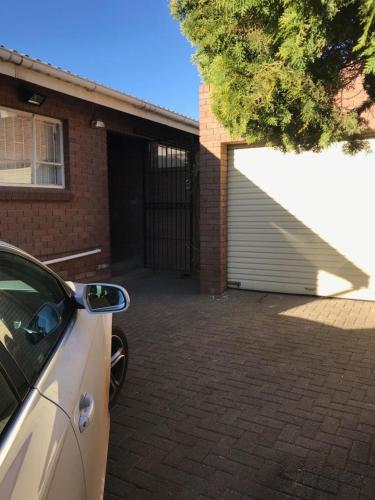 a white car parked in front of a garage at Tortilla no 3 in Bloemfontein