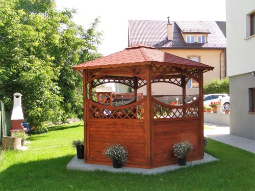 a wooden gazebo in the grass in a yard at Willa Sokołówka in Polanica-Zdrój