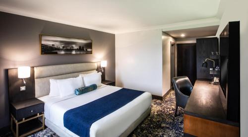 a hotel room with a large bed and a desk at Mövenpick Hotel Ikoyi Lagos in Lagos