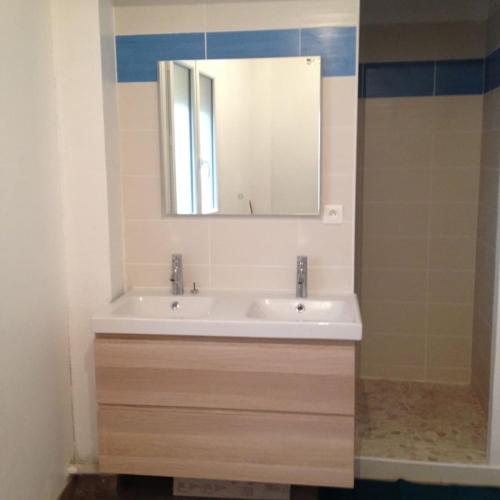 une salle de bain avec un lavabo et un miroir dans l'établissement Appartement de 80m2 au cœur de Perpignan, à Perpignan