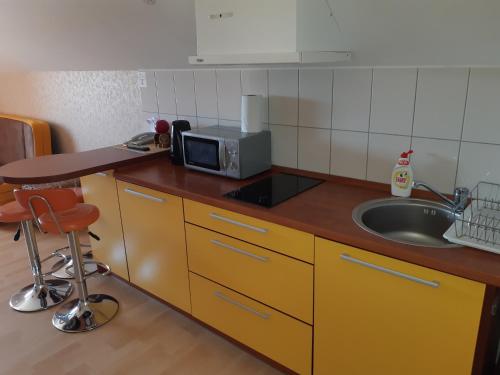 a small kitchen with a sink and a microwave at Gaspada in Sėlenai