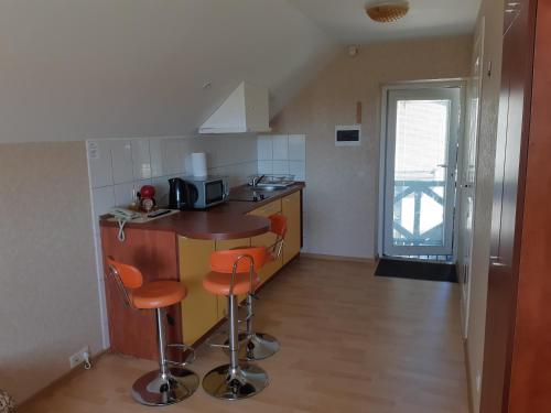 a small kitchen with a counter and stools in it at Gaspada in Sėlenai