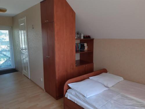 a bedroom with a bed and a wooden cabinet at Gaspada in Sėlenai