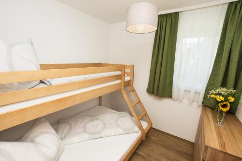 a bedroom with two bunk beds and a window at Mein Alpenstern in Filzmoos