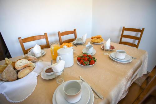 a table with a breakfast of bread and eggs at Casas da Lagariça in Sortelha