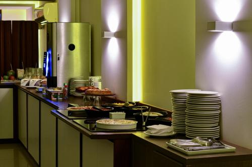 a buffet line with plates of food on a table at Littoral Gold Flat in João Pessoa