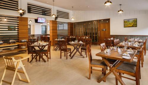 a dining room with wooden tables and chairs at The Sanihara Hotel & Resort in Vythiri