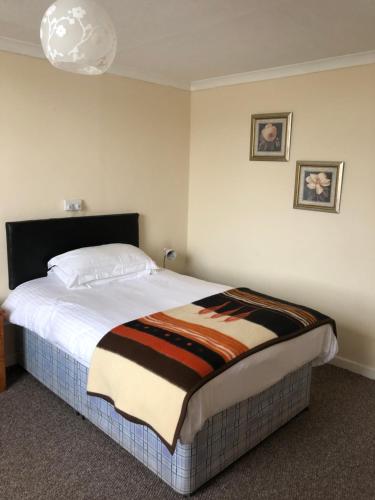 a bedroom with a bed with a blanket on it at The Hunt Lodge in Leighton Buzzard