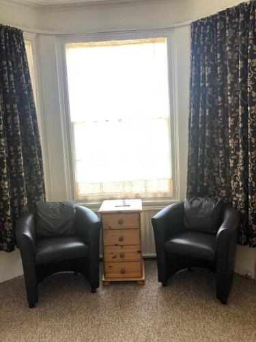 two chairs and a table in a room with a window at The Hunt Lodge in Leighton Buzzard