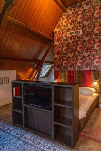 a living room with a tv and a bed at Slot Oostende in Goes