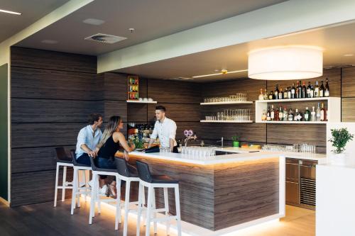 um grupo de pessoas sentadas num bar num restaurante em harry's home hotel & apartments em Munique