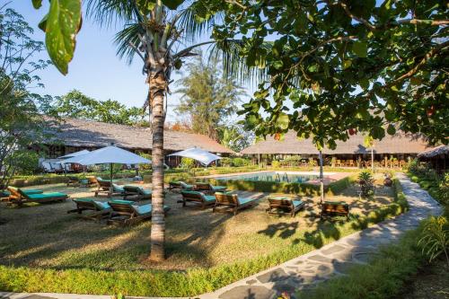 a resort with a pool and chairs and umbrellas at Corail Noir Hotel in Ambaro