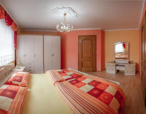 a bedroom with a large bed and a chandelier at APARTMA AJDA in Komenda