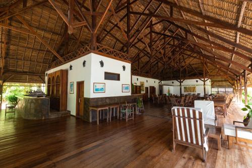 a large room with a table and chairs in a building at Corail Noir Hotel in Ambaro