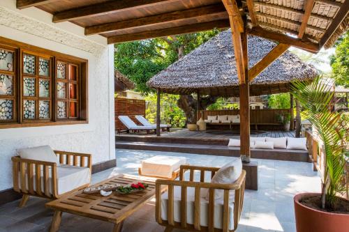 an outdoor patio with a table and chairs and a pavilion at Corail Noir Hotel in Ambaro