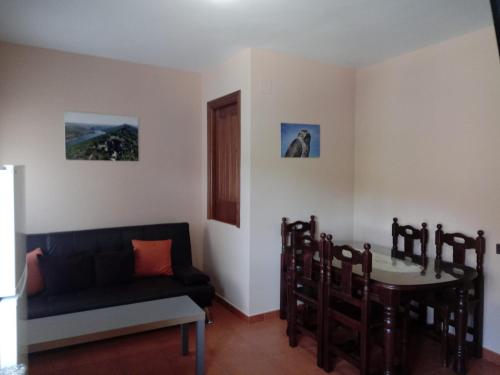 a living room with a couch and a table at Casa Rural Al-Mofrag y Apartamentos El Mirador de Monfragüe in Villarreal de San Carlos